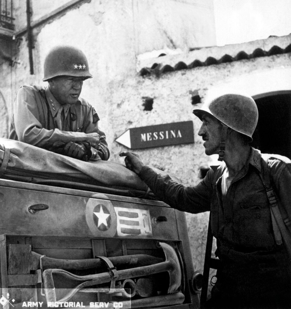 George Patton observando tropas durante a campanha